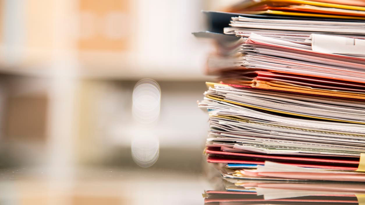A stack of papers on a table in an office.