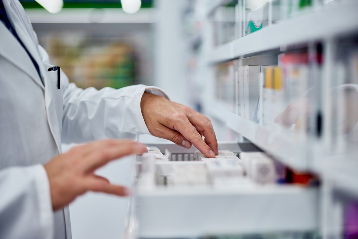 Pharmacist getting medicine out of a drawer at pharmacy