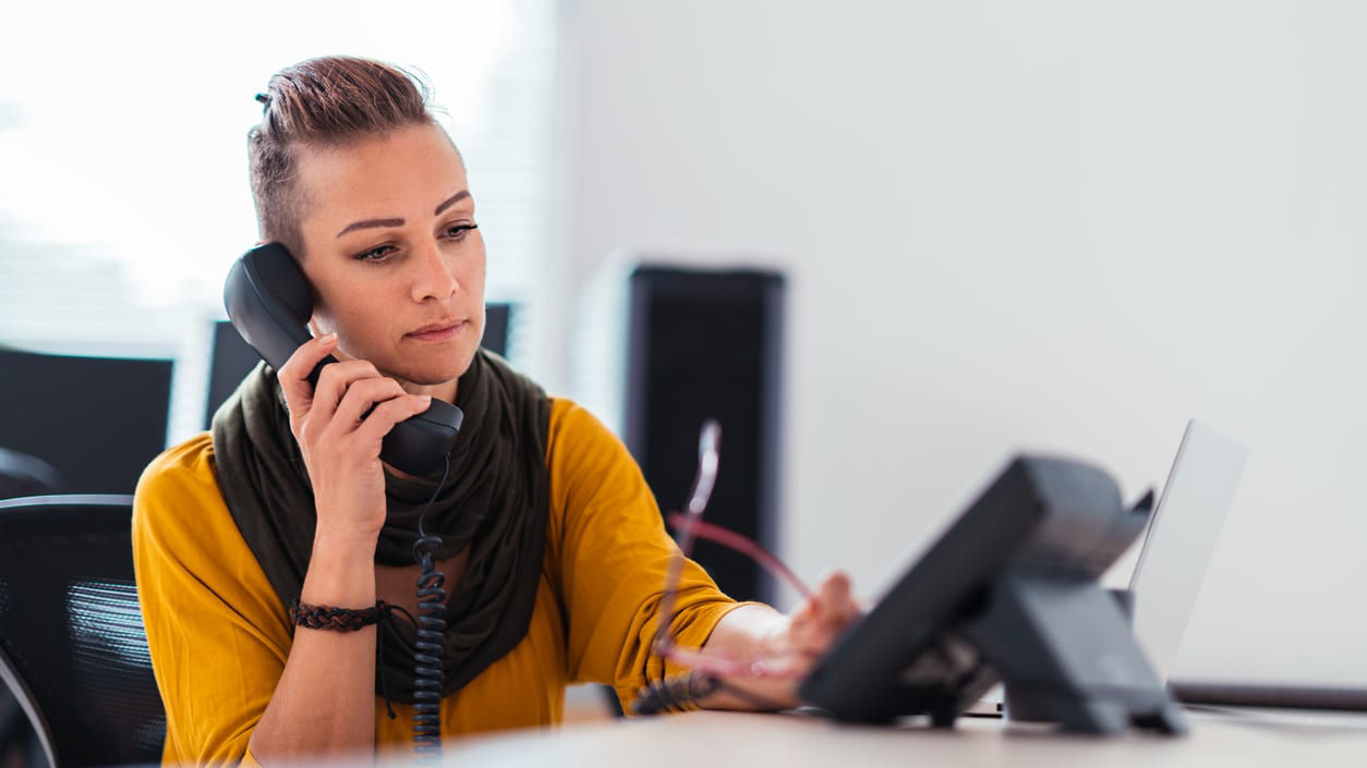 A woman talking on the phone in an office.