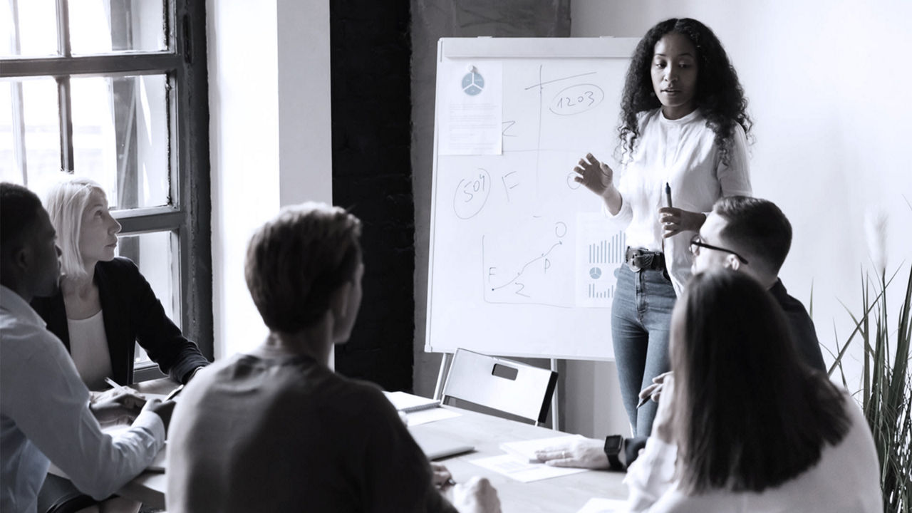 A woman giving a presentation to a group of people.
