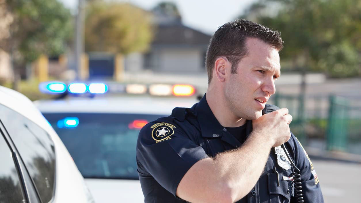 A police officer talking on his cell phone.