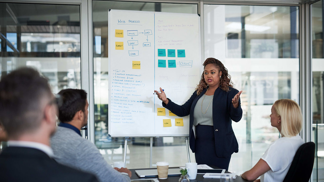 A woman giving a presentation to a group of people.