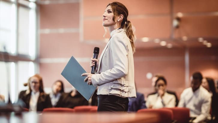 A business woman giving a presentation in a conference room.
