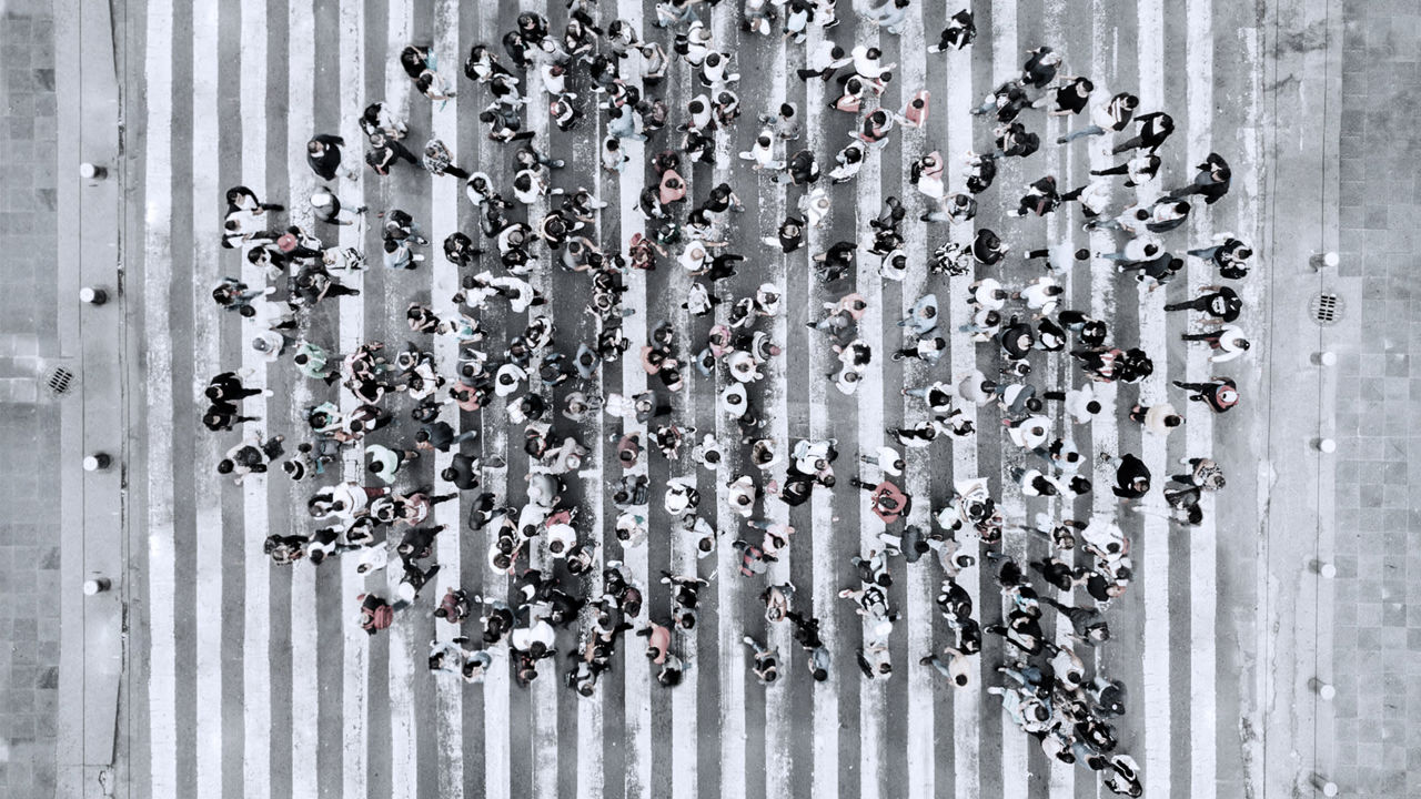 A group of people walking across a crosswalk.