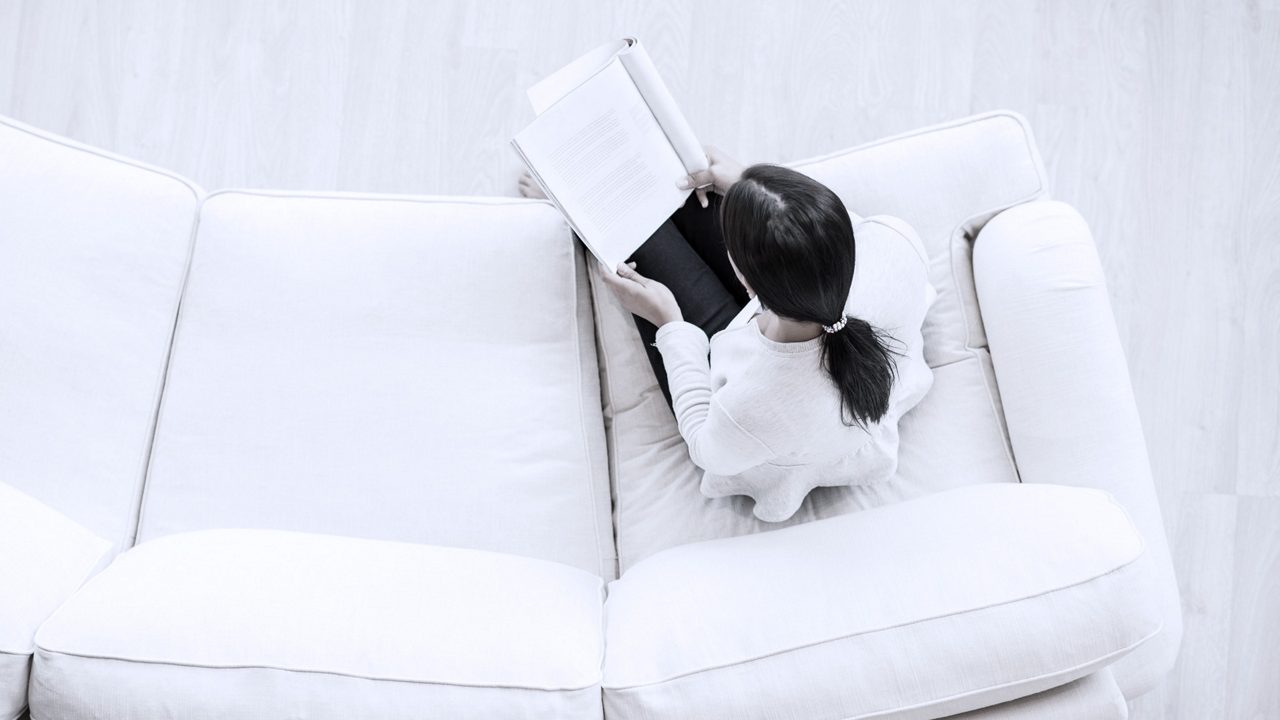 Business professional reading a book on a couch