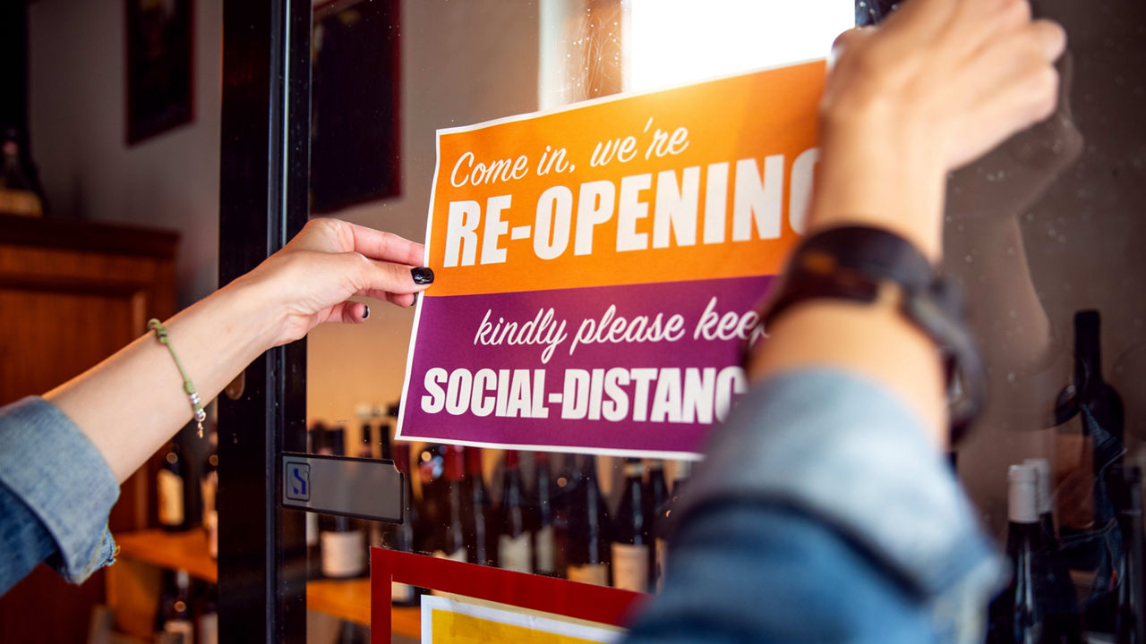 A woman is holding a sign that says social distancing.