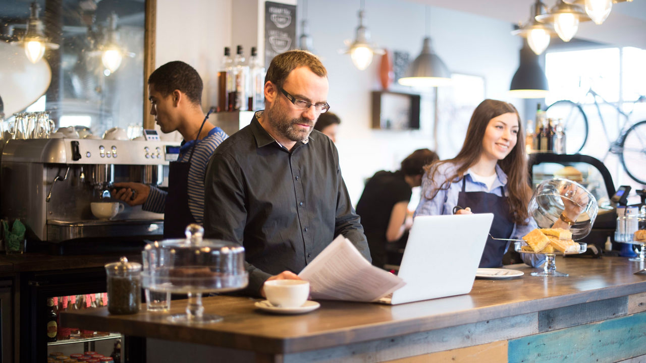 A group of people working at a counter in a coffee shop.