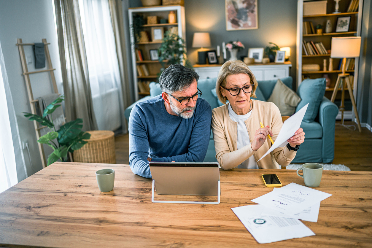 Mature couple manages expenses and bills together at home