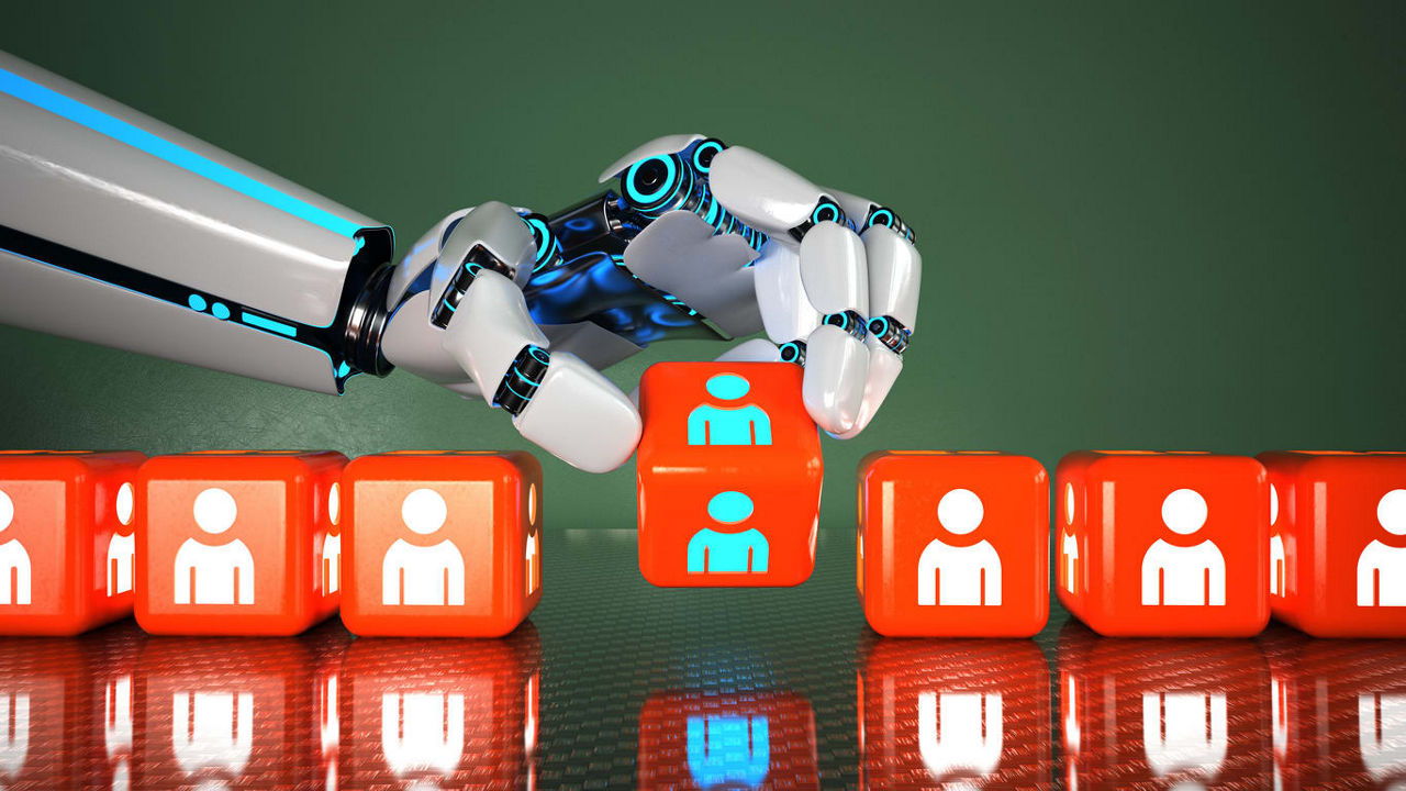 A robot is holding a red cube with people on it.