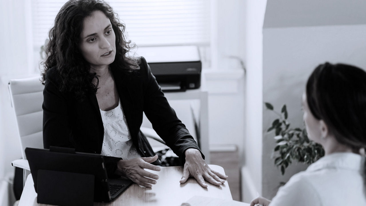 Two women talking in office meeting