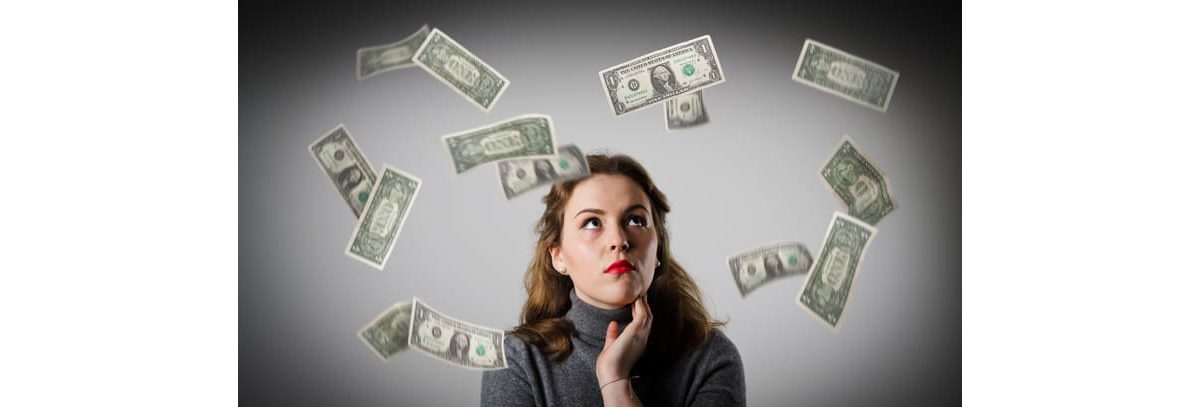 A woman looking up at money falling from the sky.