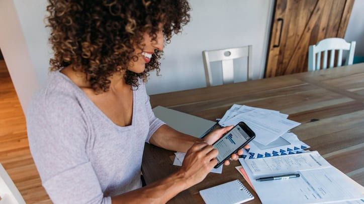 A woman looking at her phone while sitting at a table.