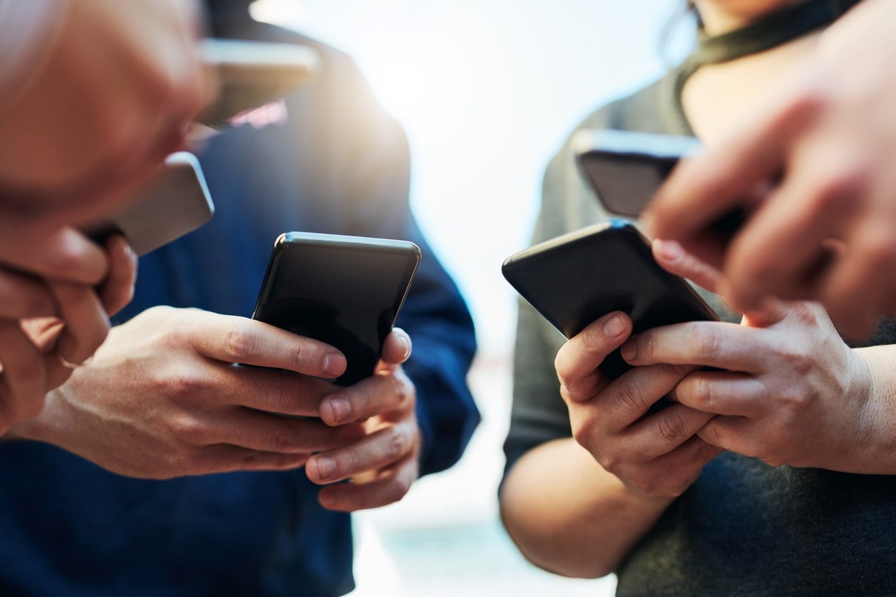 A group of people using their smartphones.