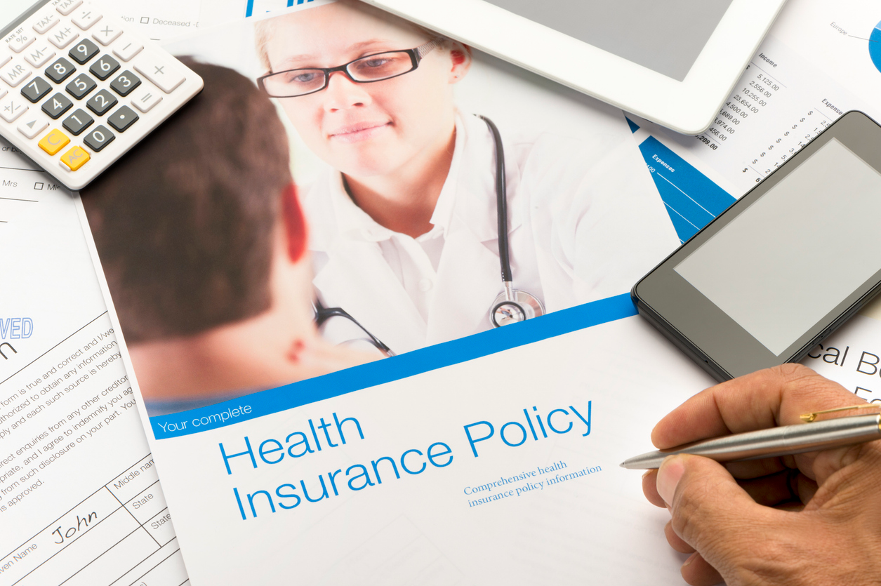 Health Insurance Policy brochure with paperwork. There is also a mobile phone and digital tablet in the image. The included image can also be found in my portfolio. Image # 22268159