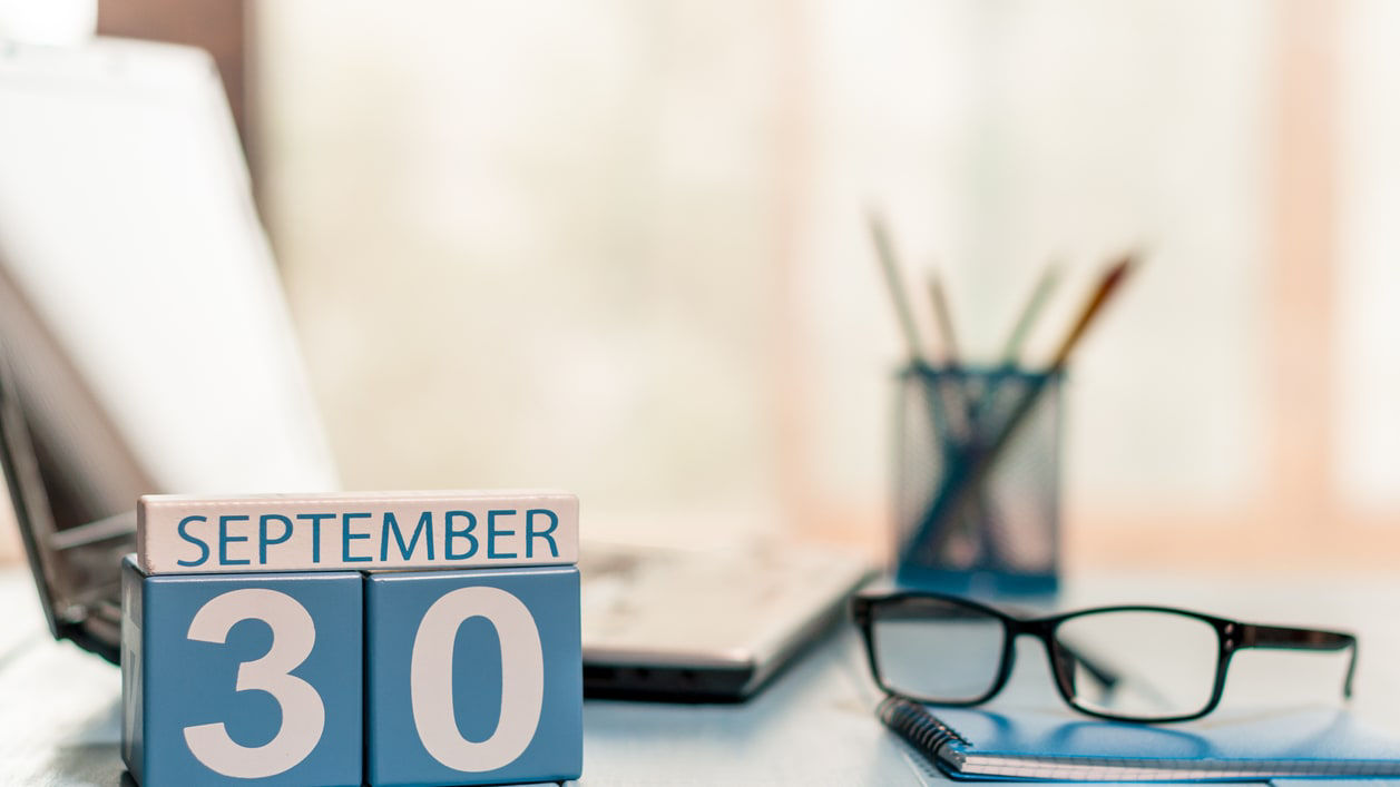 A calendar with the word september 30 on it sits on a desk.