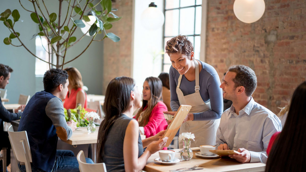 A group of people sitting at tables in a restaurant.