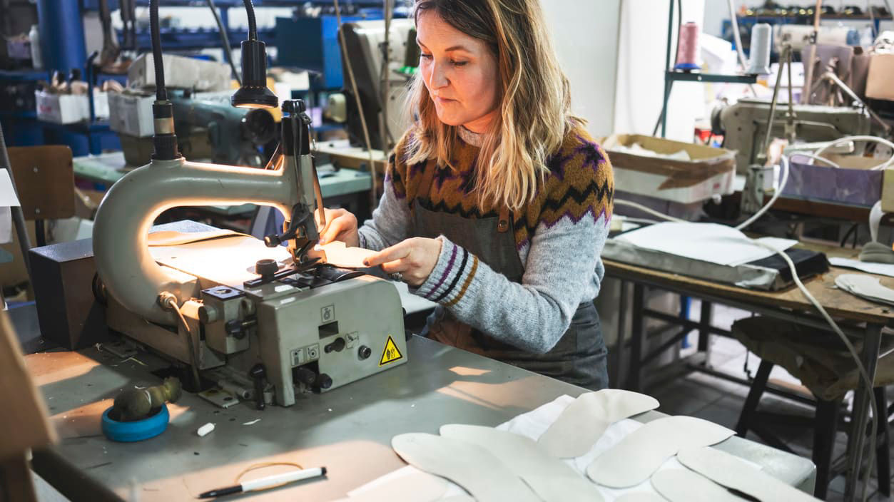 A woman working on a sewing machine in a factory.