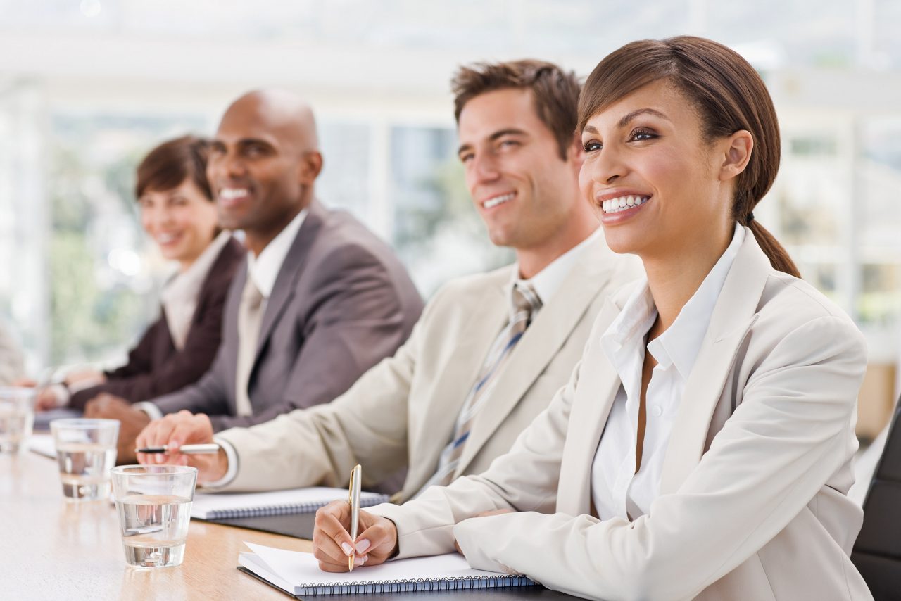 Women and Men Executives Sitting in a Board Room