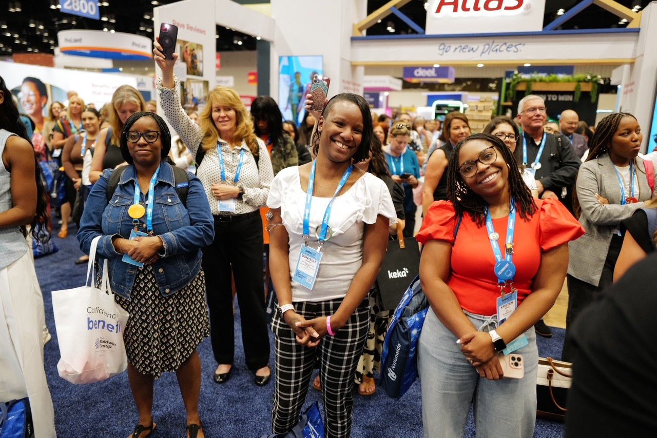 group of people with conference badges smile for the camera