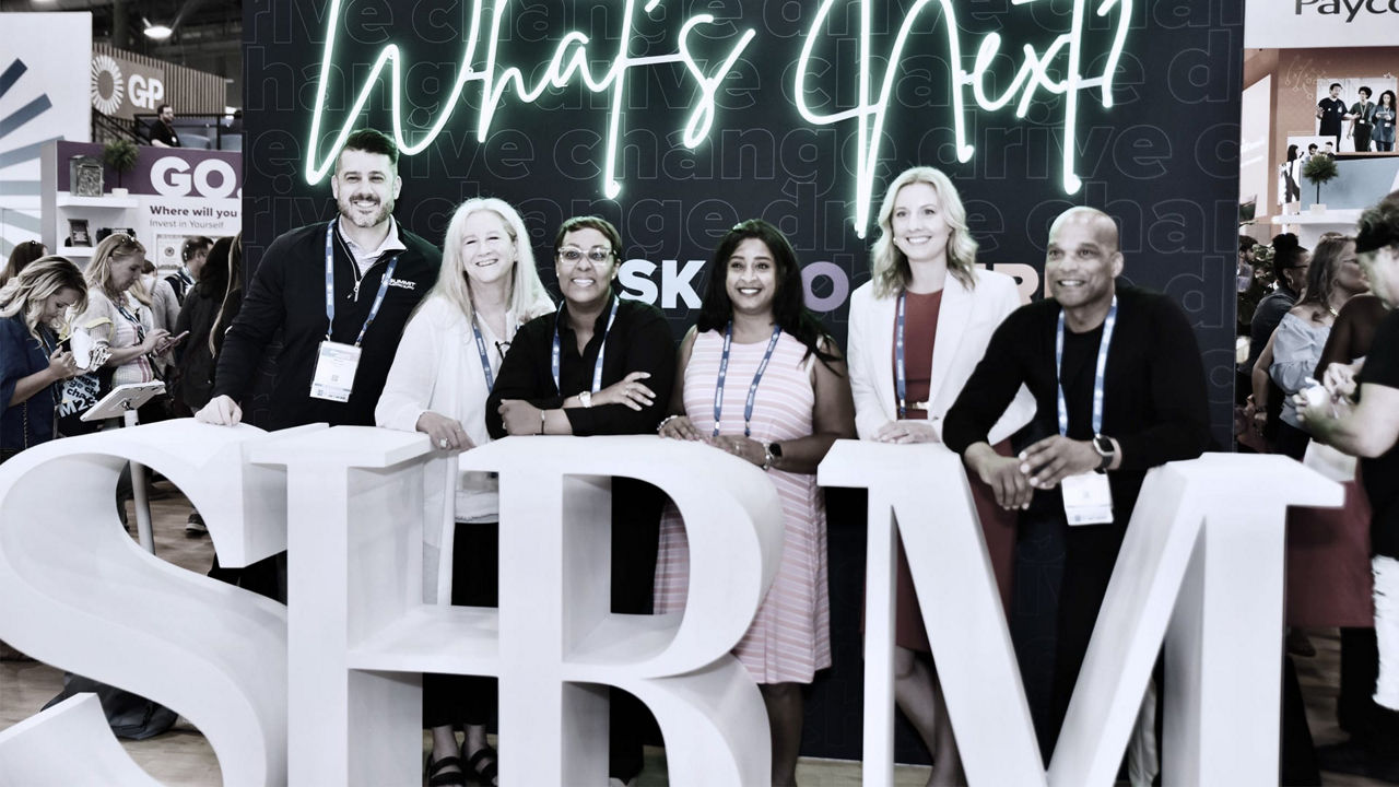 A group of people standing in front of a sign that says srm.