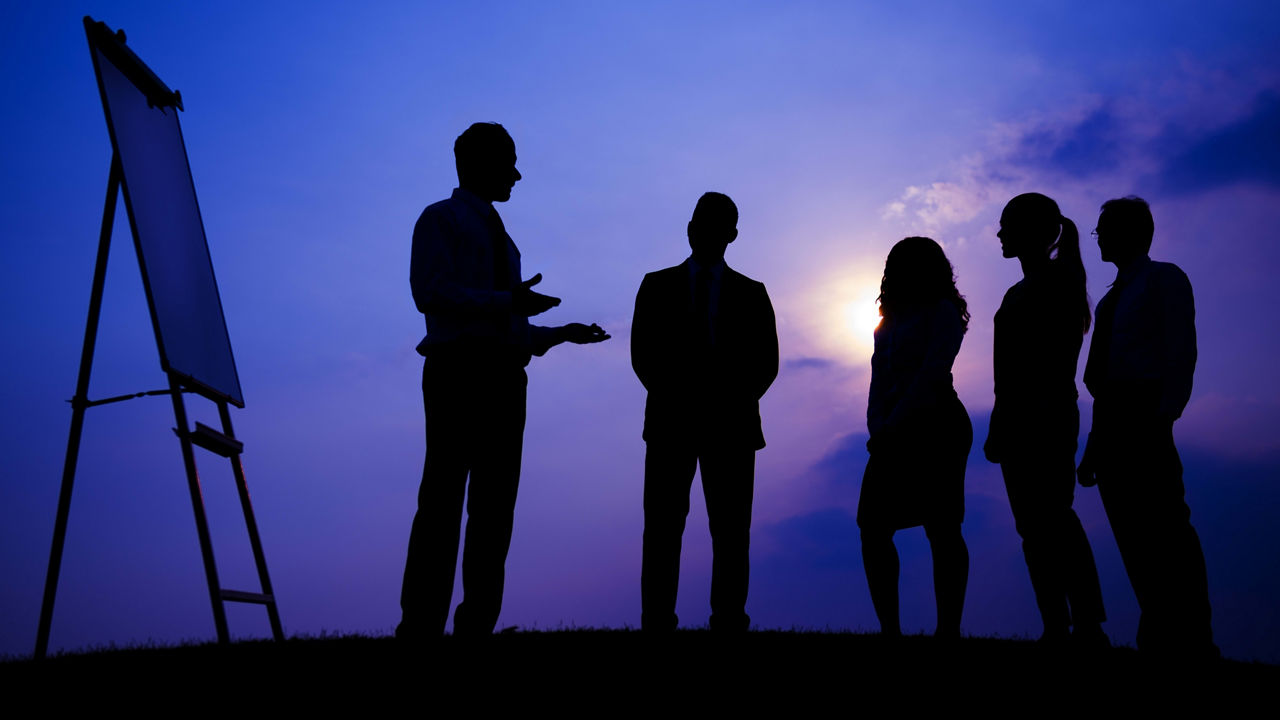 Silhouette of a group of business people at sunset.