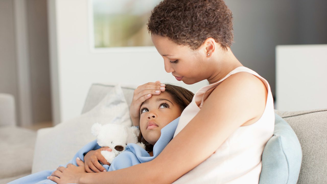 A mother holding her ill daughter.