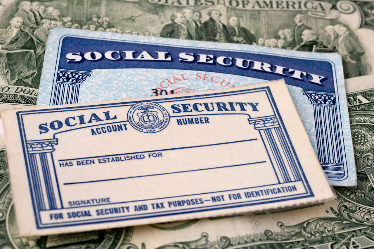 "Close up photograph of Social Security cards against currency background, selective focus.Similar Images:"