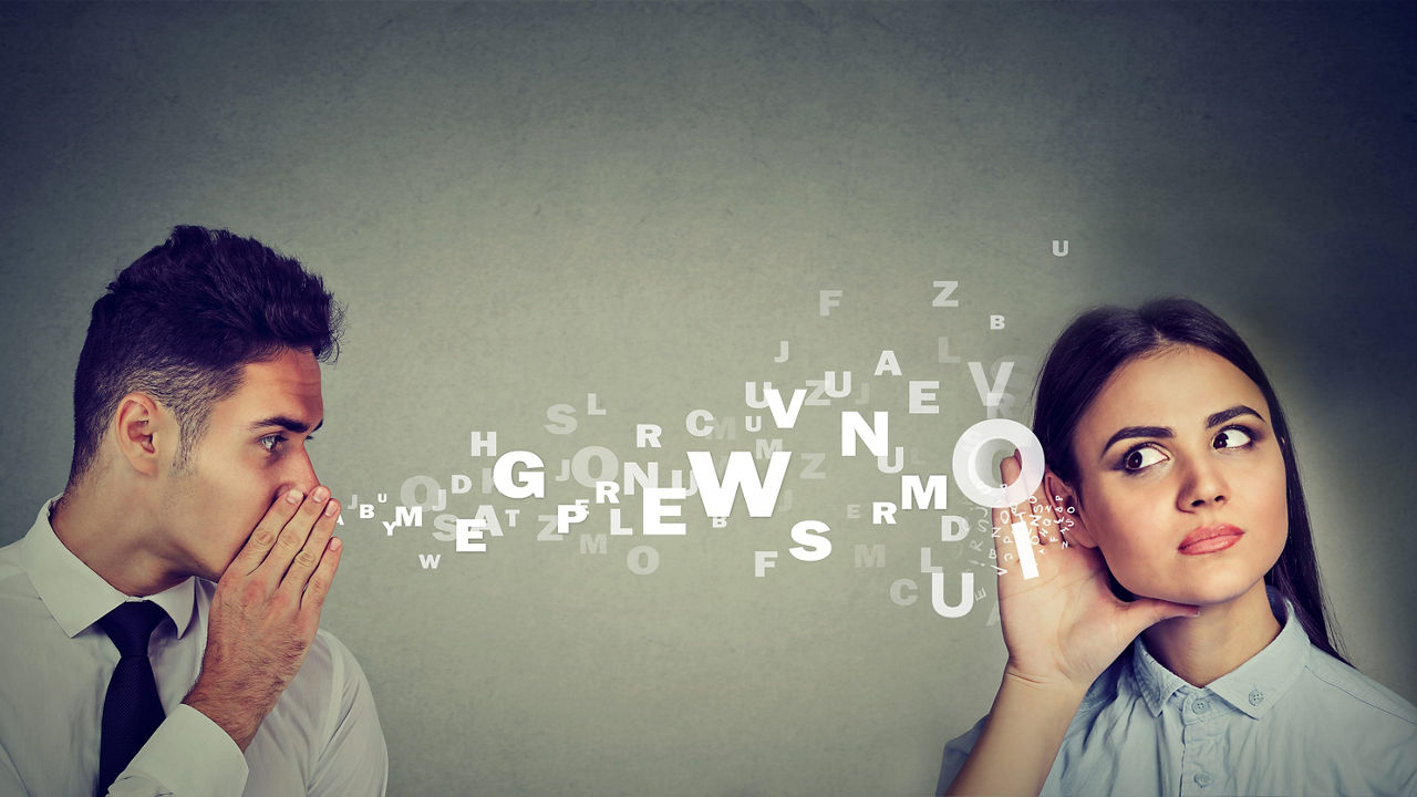 A man and a woman are talking with letters coming out of their mouths.