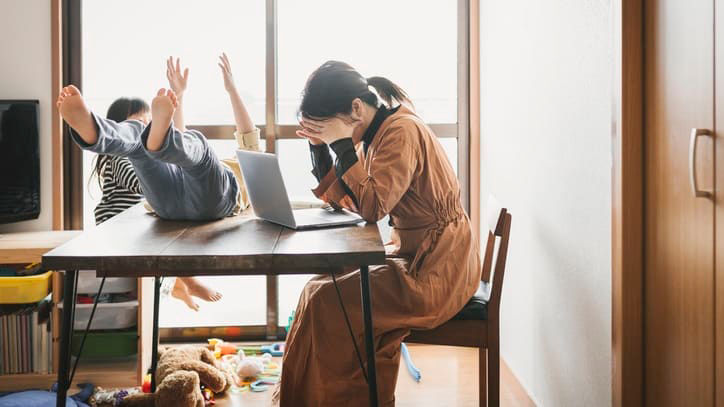 A group of people sitting at a table with a laptop in front of them.