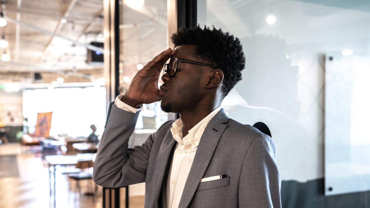 A man in a suit and tie is looking at his phone.