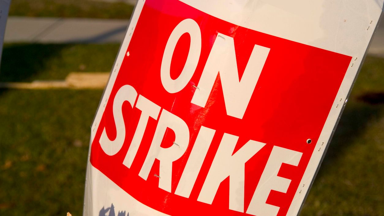 Picket sign reads "On Strike"