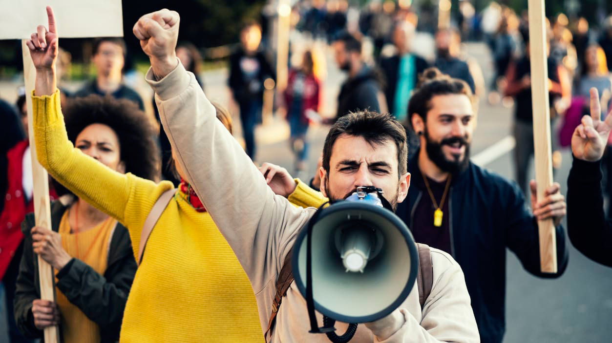 A group of people holding signs and a megaphone.