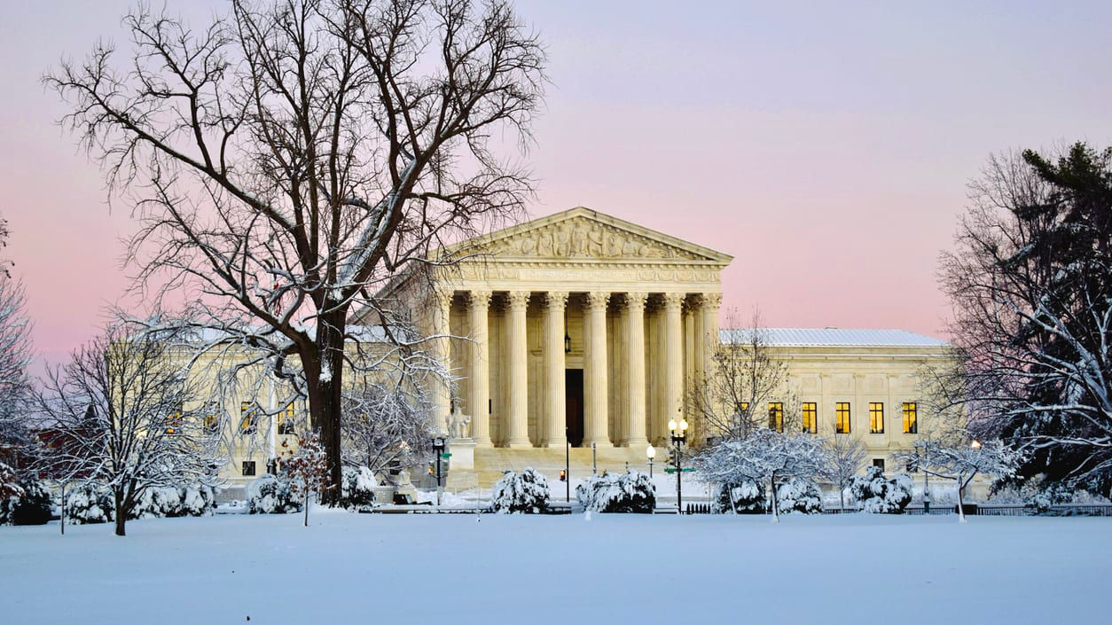 The supreme court building is covered in snow.