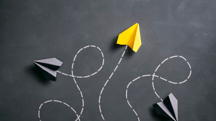 Paper airplanes flying in the air on a blackboard.