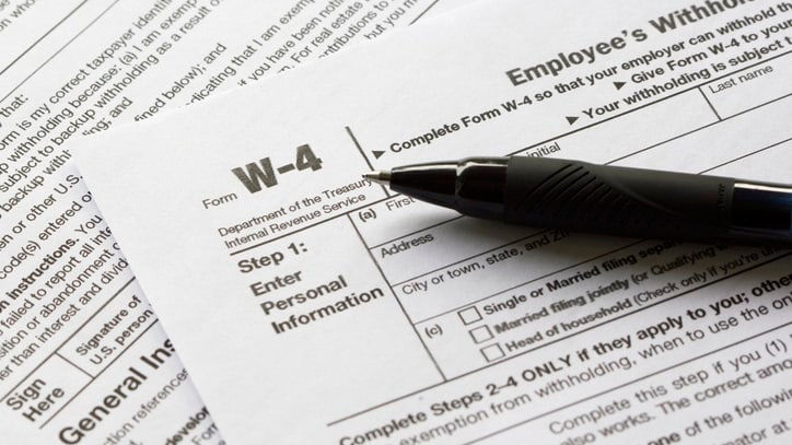 A pen sits on top of an employee tax form.