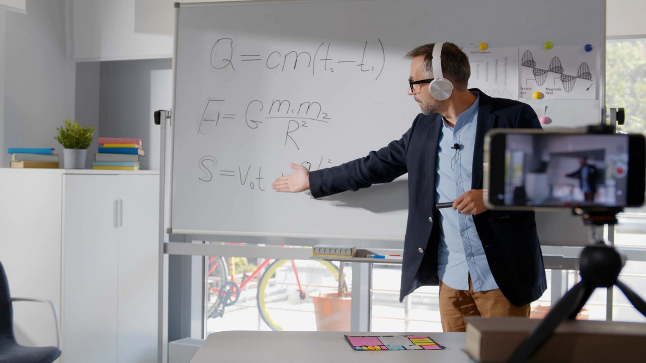 A man is standing in front of a whiteboard.