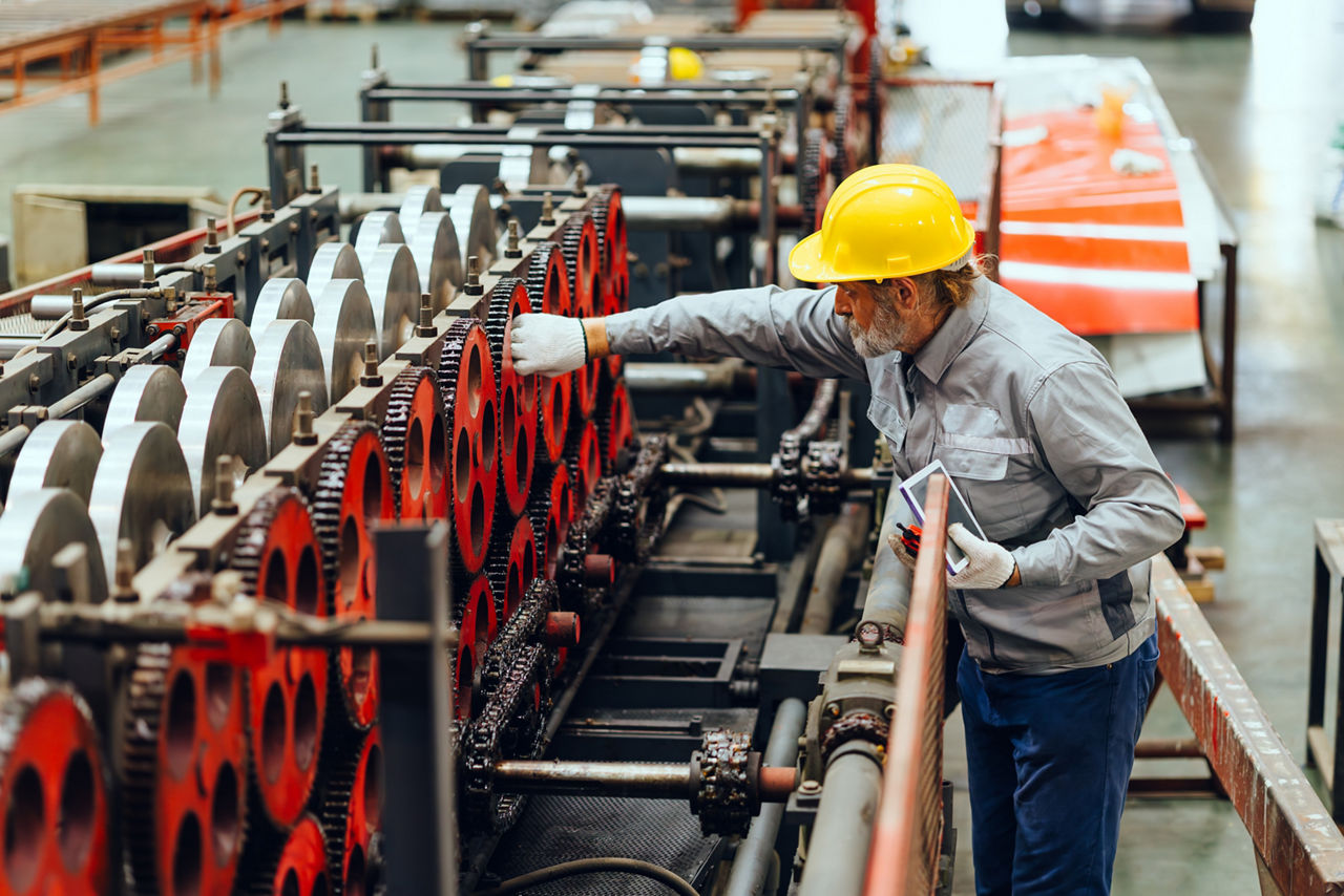 Expert technician worker checking machine in plant factory.