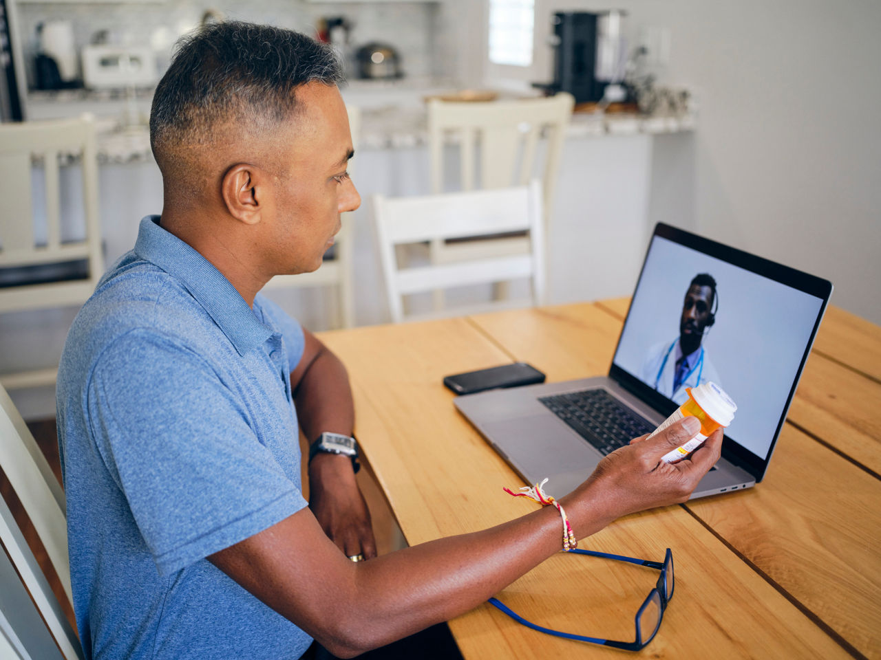 A mature Indian man on a video call with his doctor.