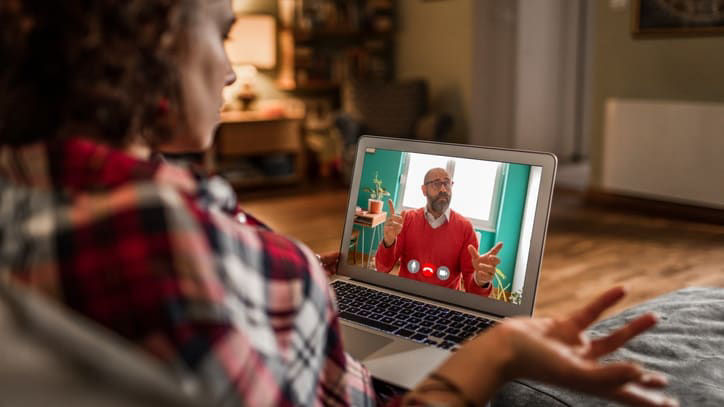 A woman is watching a video on her laptop.