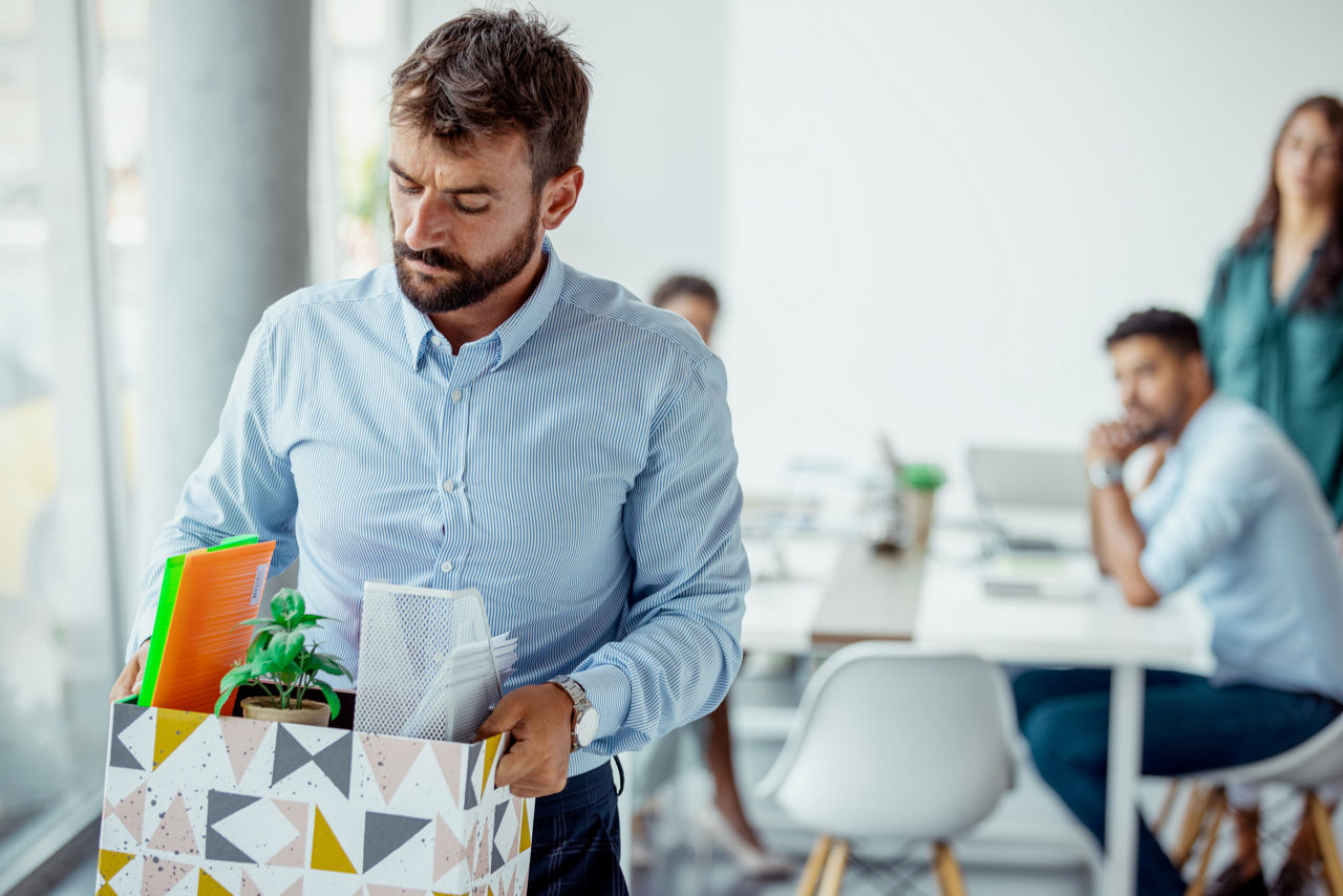 A male employee packs his belongings after getting laid off from his job.