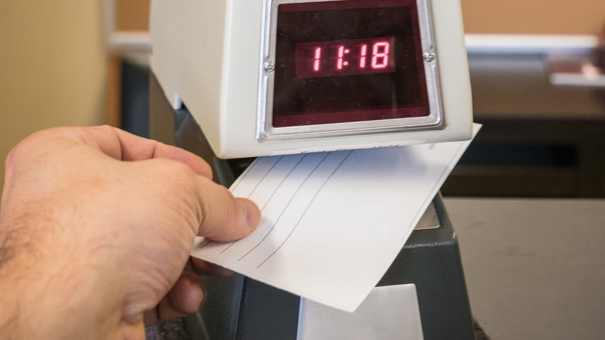 A hand is holding a timer on top of a paper.