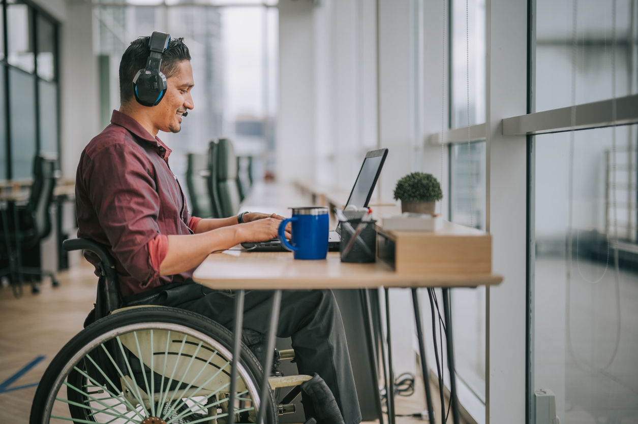asian indian male white collar worker with disability on wheelchair talking to the camera video calling video conference with his business partners