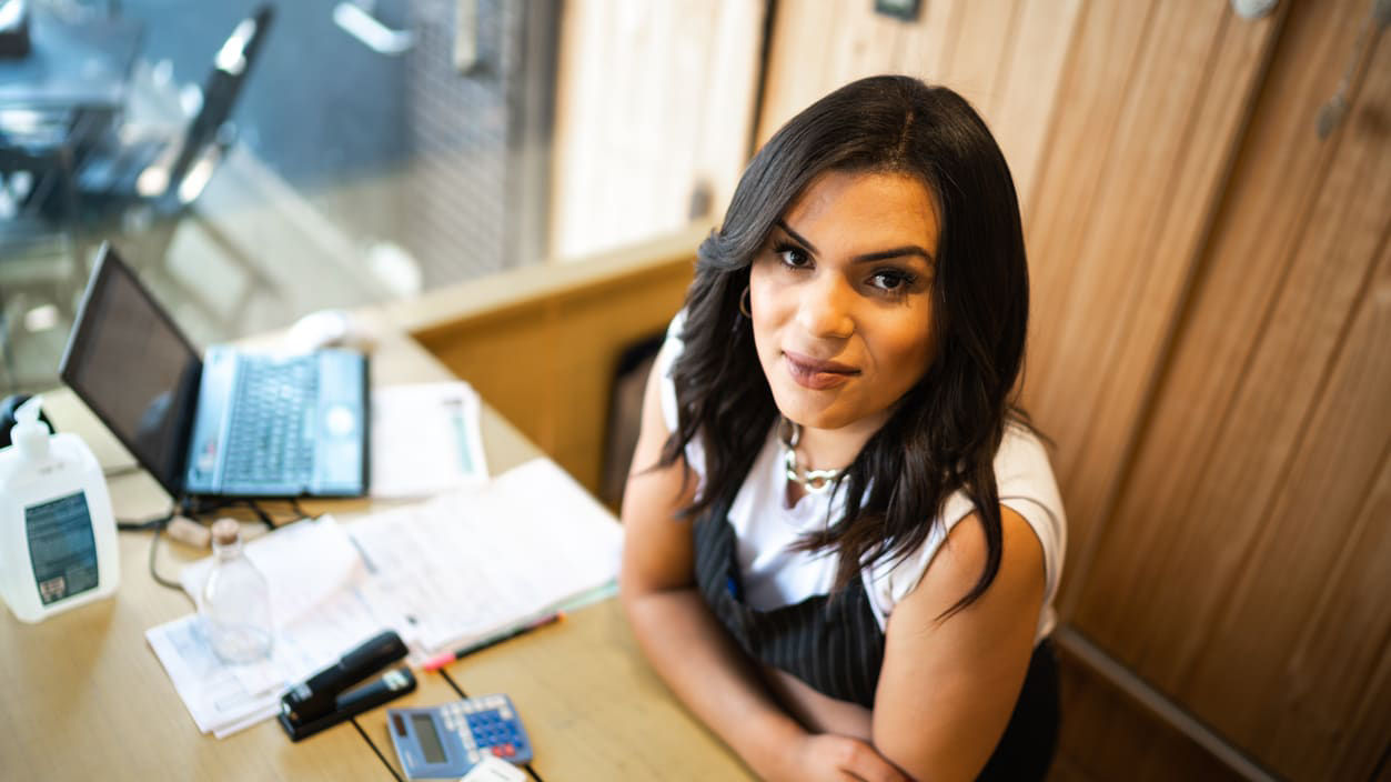 A woman sitting at a desk with a laptop.