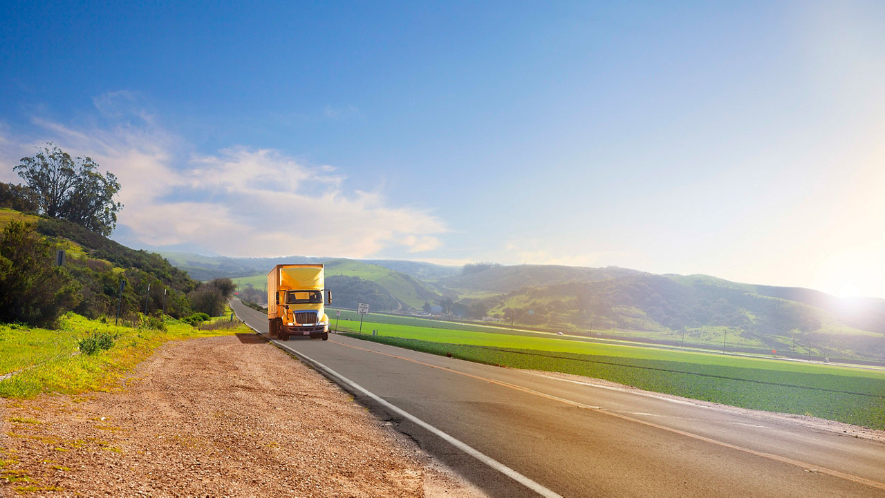 A large truck driving down a country road.
