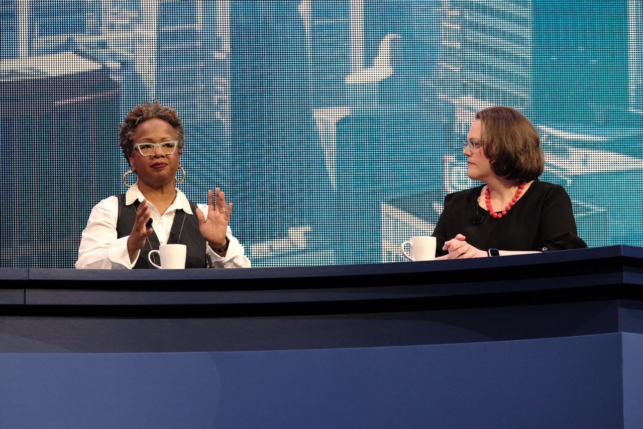 Janet Gipson and Svenja Gudell speak on the main stage as part of a panel of four