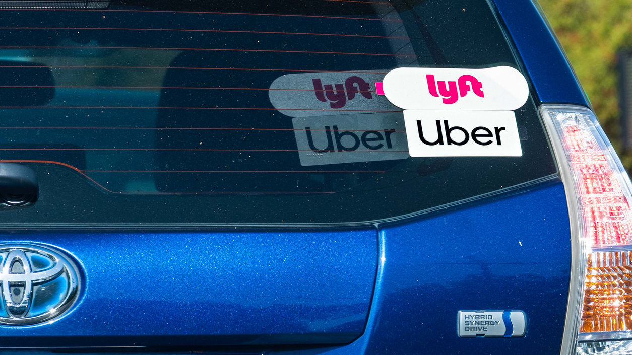 A car with lyft and Uber stickers on it.