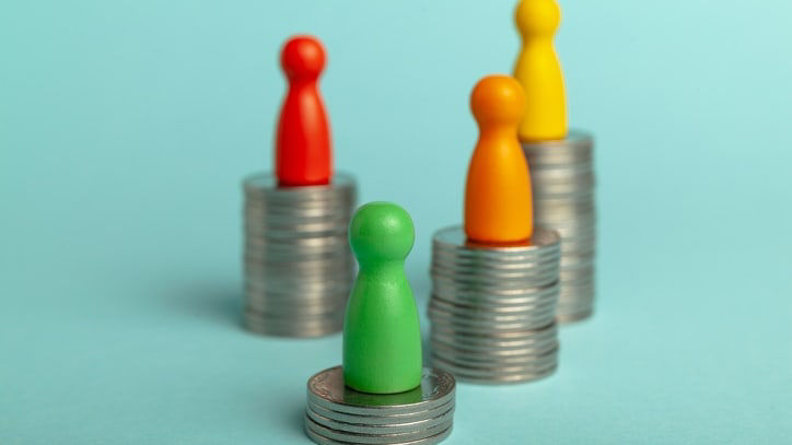 Colorful people standing on top of stacks of coins.