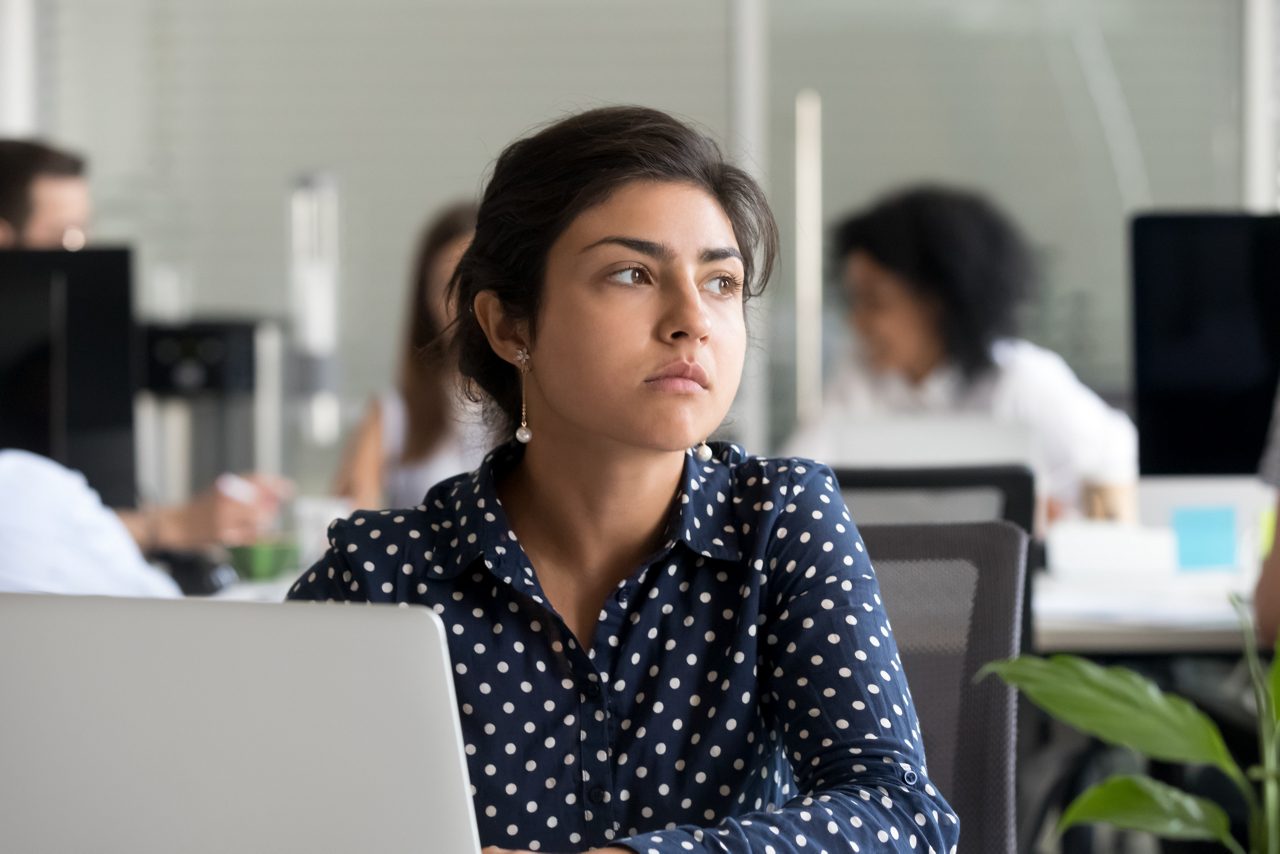 Unhappy woman sits at work station