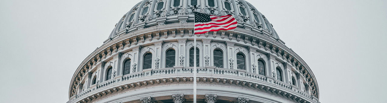 U.S. Capitol rotunda with the U.S. flag flying before it