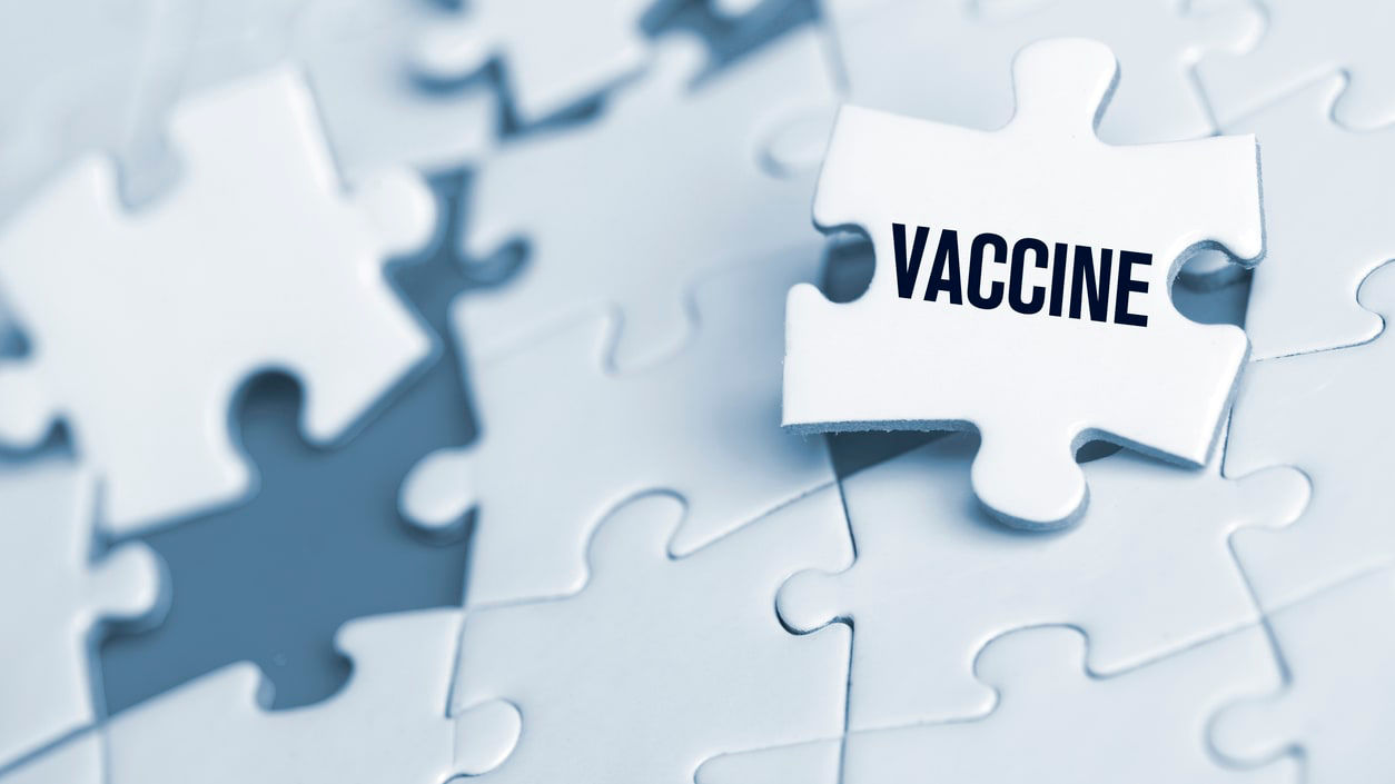 A puzzle piece with the word vaccine on it.